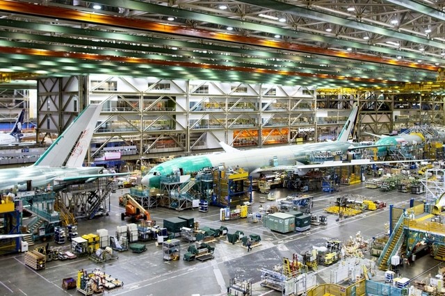 Para pekerja sedang menyelesaikan perakitan pesawat Boeing 777.